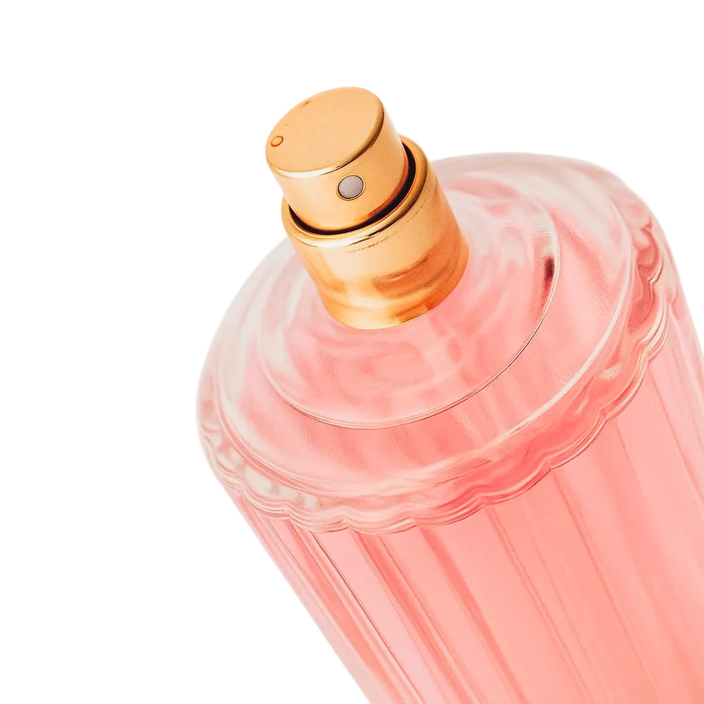 Pink perfume bottle with gold cap on a white background